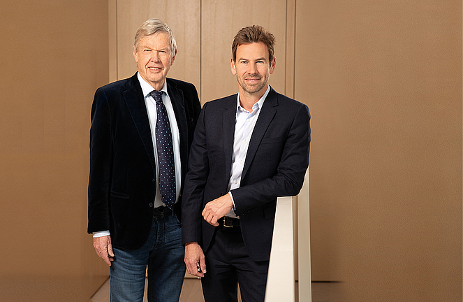 Two men of different ages wearing blazers